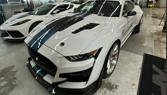 A white and black car parked in a room.