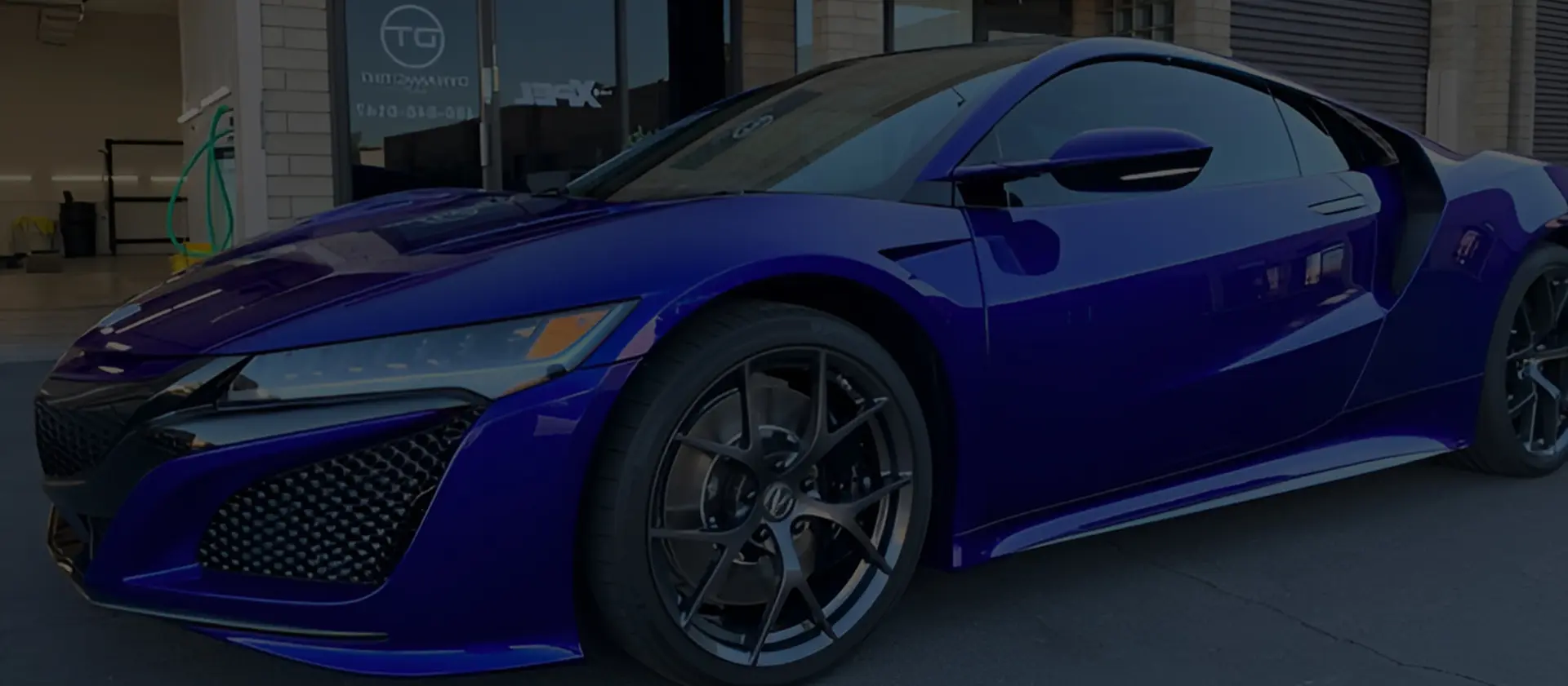 A blue car parked in front of a building.