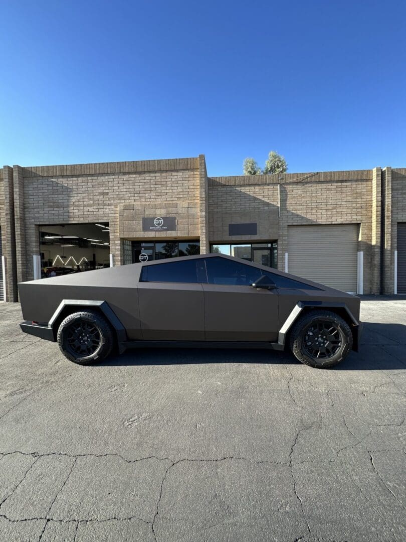 A black car parked in front of a building.