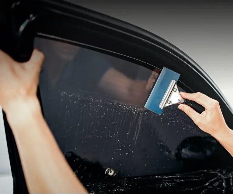 A person is cleaning the window of their car.