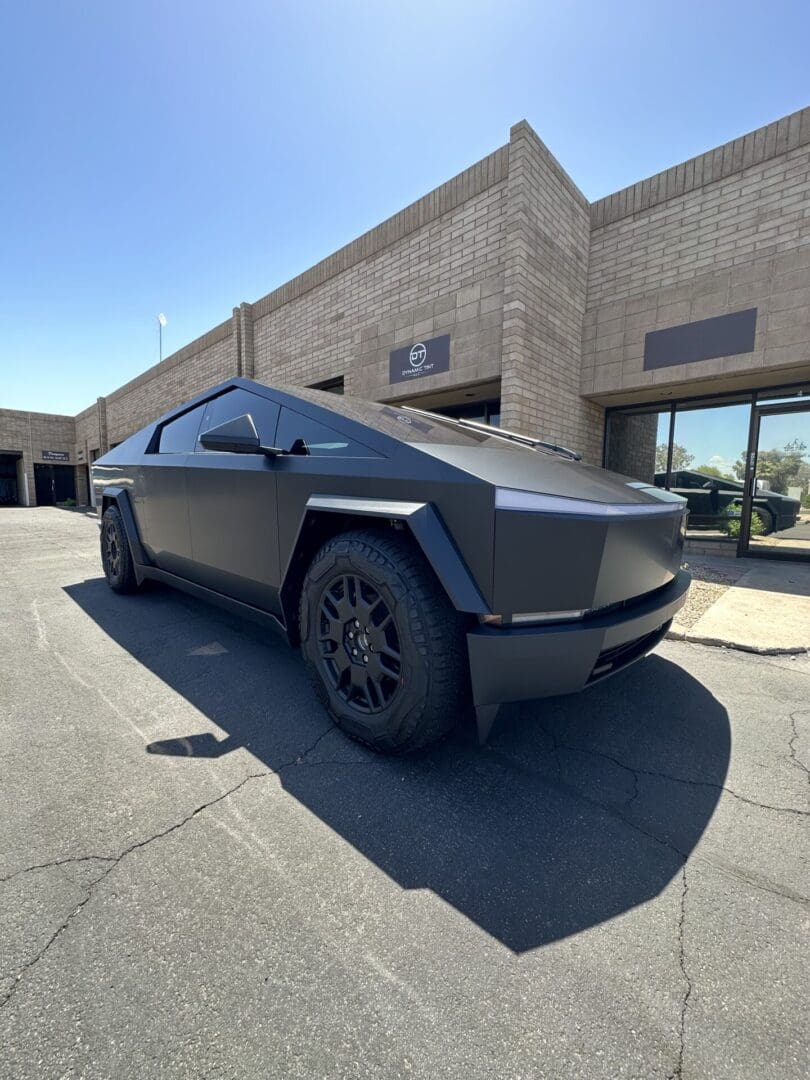 A black car parked in front of a building.