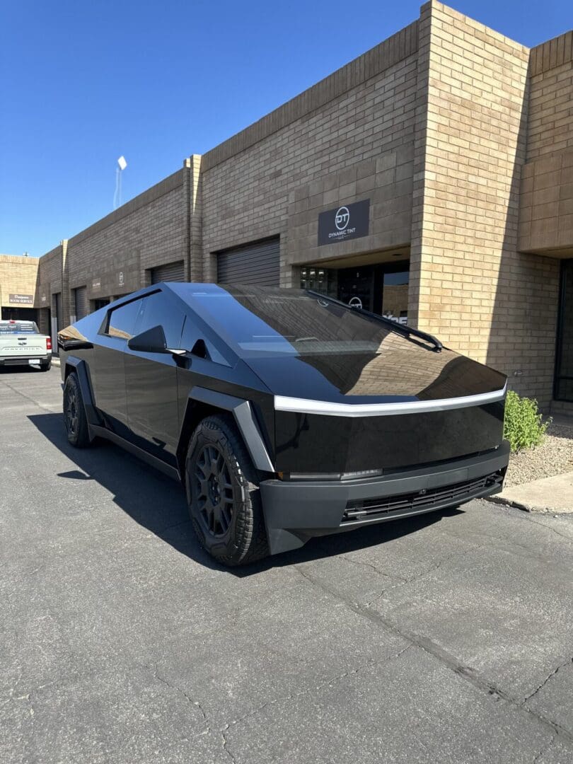 A black car parked in front of a building.