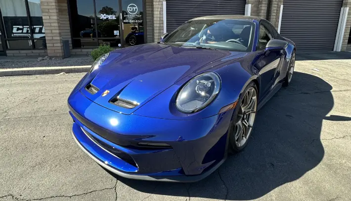 A blue car parked in front of a building.