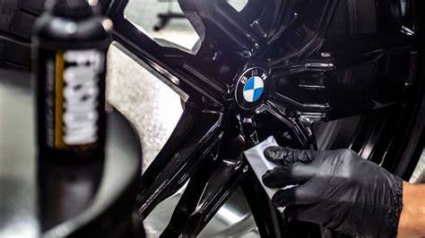 A person is working on the wheel of a bmw.